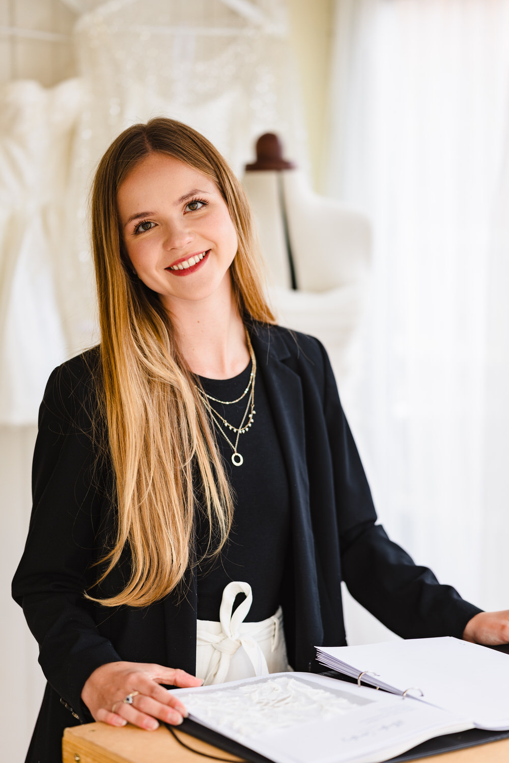 brand photo of phoebe crosby design in her studio wearing white trousers and a black jacket
